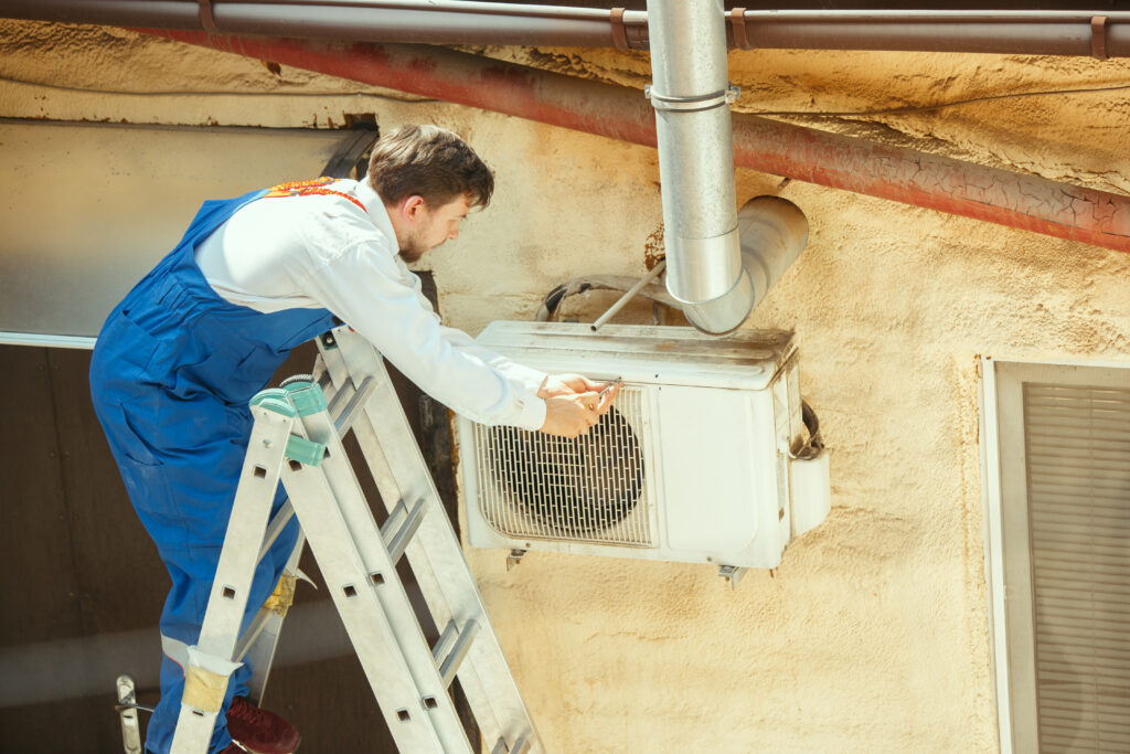 HVAC technician working on a capacitor part for condensing unit