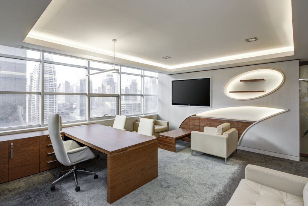 office-sitting-room-executive-sitting Gray Office Rolling Chair Near Brown Wooden Desk in Front of Flat Screen Tv on White Painted Wall