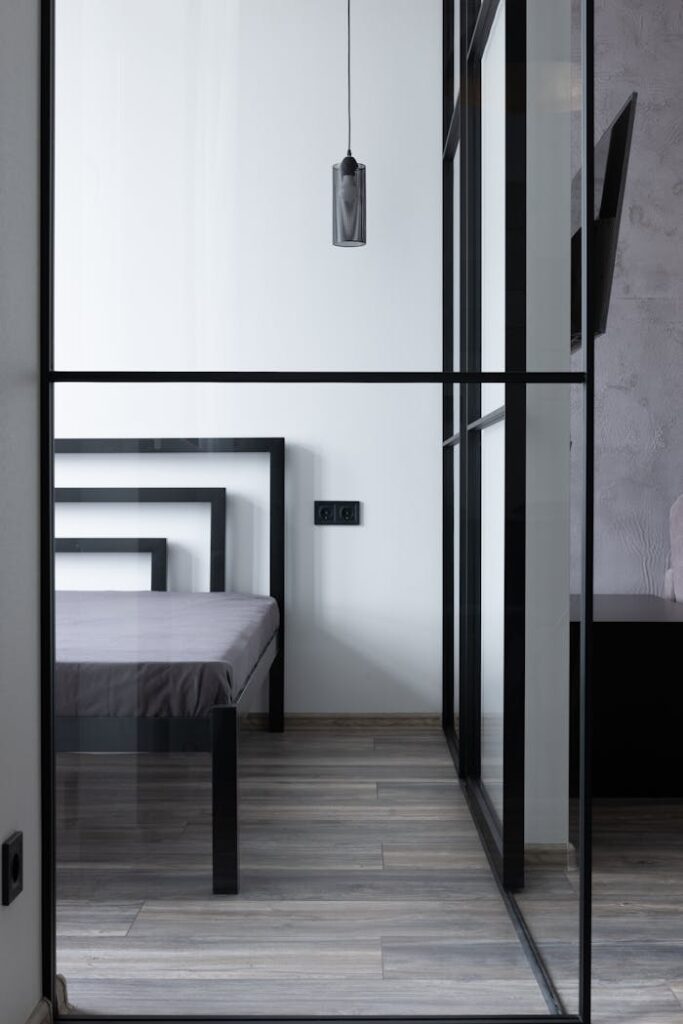 pexels-photo-6436782 Contemporary bed with mattress and holes in house with hanging lamp and glass division in daytime